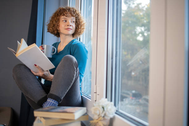 istock Happy woman reading book at home 1440040990