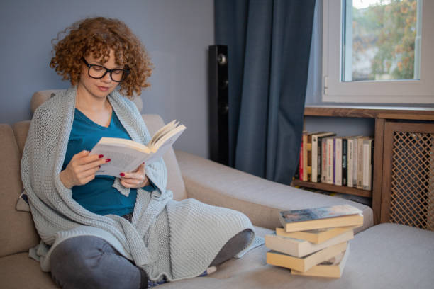 istock Happy woman reading book at home 1440041037