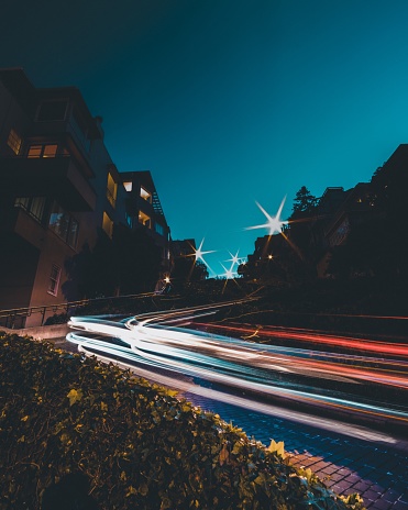 A timelaps of car lights on the road with a blue sky in the background at night time