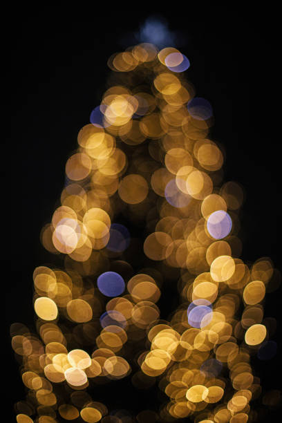 istock Blurred christmas tree golden festive lights in evening. Abstract christmas tree, illumination bokeh. Atmospheric winter holidays. Merry Christmas and Happy Holidays 1440047054