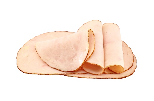 Slices of chicken cold cut ham on white background. Close up.