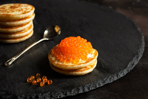 caviar vermelho em uma ardósia - appetizer caviar gourmet blini - fotografias e filmes do acervo