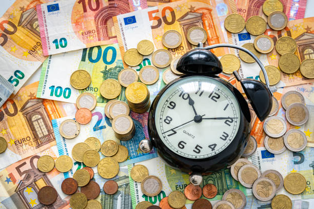 time is money concept. alarm clock on european union currency. - european union euro note currency forex european union currency imagens e fotografias de stock