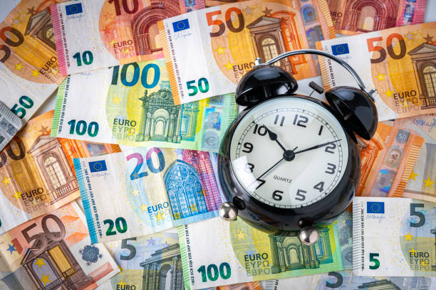 koncepcja czasu to pieniądz. budzik na banknotach euro - euro symbol crisis time debt zdjęcia i obrazy z banku zdjęć