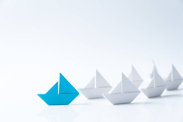 Leadership conceptual using blue paper ship stock photo