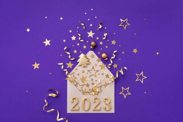 Creative Christmas and New Year ornament with envelope, holiday decorations, confetti stars and golden 2023 numbers. Top view and flat lay. stock photo