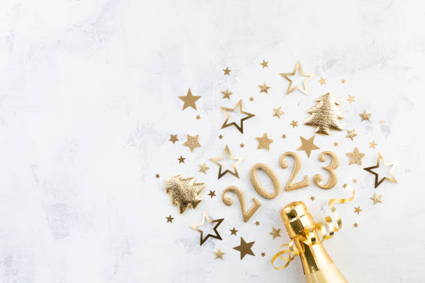 Christmas and New Year background with golden champagne bottle, party decorations, confetti stars and 2023 numbers. Christmas and New Year background with golden champagne bottle, party decorations, confetti stars and 2023 numbers concept. new years day photos stock pictures, royalty-free photos & images