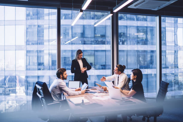 istock Diverse colleagues teamworking on project ideas sitting at desk with modern technology, successful female director checking time while intelligent multiracial partners brainstorming for cooperation 1440053305