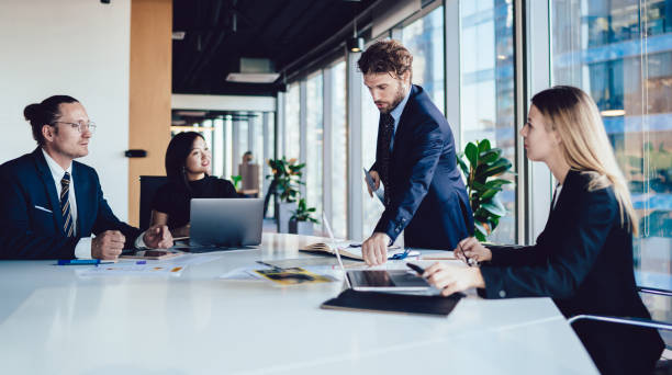 istock Modern executive male and diverse colleagues at desk in office 1440053334