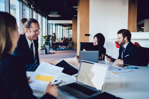 istock Smiling multiethnic formal people working at desk in open space 1440053343