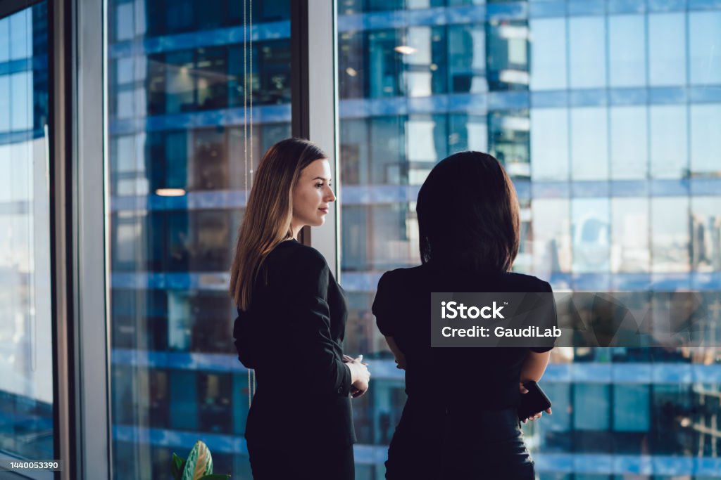 Confident female colleagues dressed in formal wear talking about business in office company, Caucasian woman employees discussing planning and ideas for briefing cooperation of corporate firms Business Stock Photo