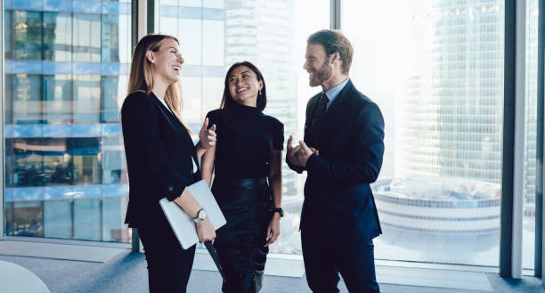istock Cheerful group of multiracial colleagues talking in office hallway 1440053995
