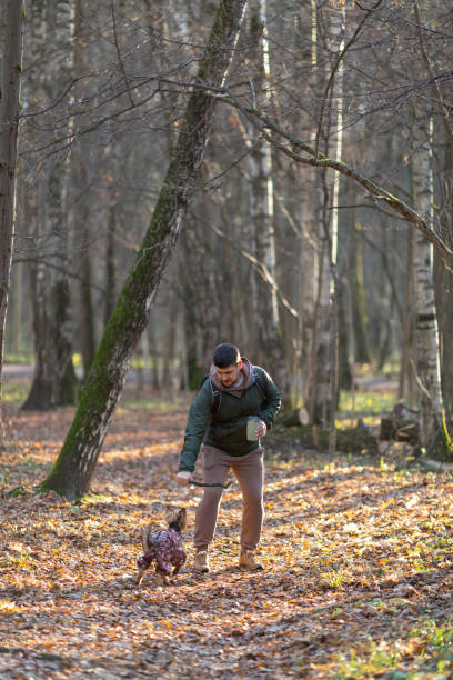 istock A man walks with a dog in the autumn forest 1440054368