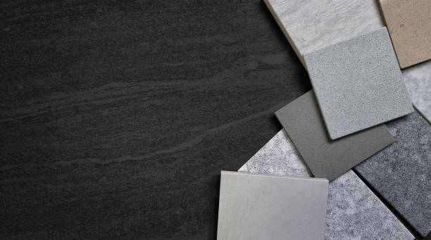 istock multi color of grainy artificial stones (quartz) and stone tiles samples placed on dark black travertine marble background. palette of interior stone material samples with blank space for design. 1440054621