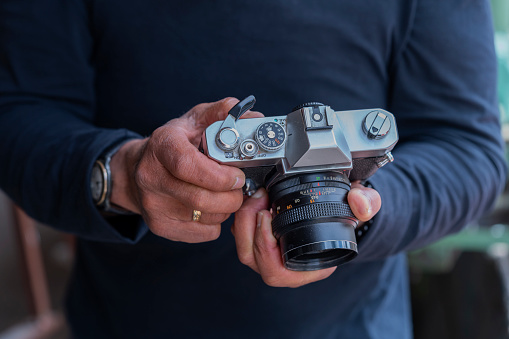 Photograph of the hands of an older man holding a camera