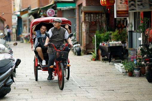 Two men on a tricycle ride around Changhua's Lukang Street and take a guided tour of the local scenery and culture