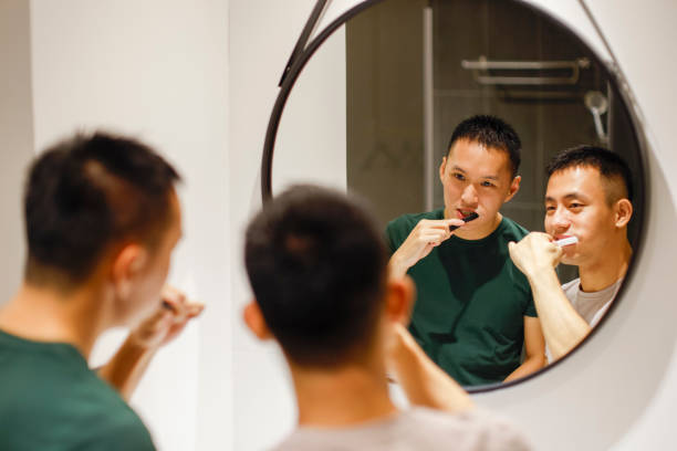 istock Two men brushing teeth and washing up together in hotel bathroom 1440056580
