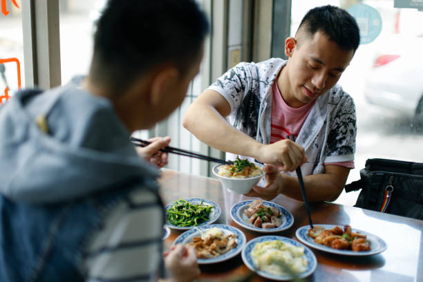 Two men order meals and enjoy delicious food at a snack bar in Lukang, Changhua, Taiwan