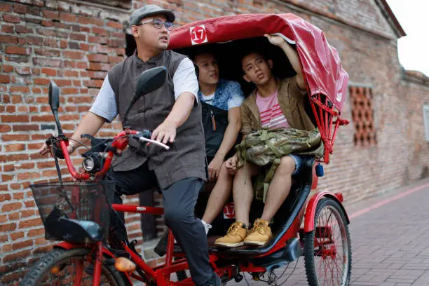 Two men on a tricycle ride around Changhua's Lukang Street and take a guided tour of the local scenery and culture
