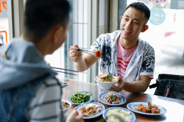 Two men order meals and enjoy delicious food at a snack bar in Lukang, Changhua, Taiwan