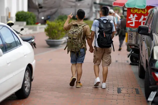 Two men walking on Lukang Street in Changhua, Taiwan; exploring local traditional architectural features and food culture