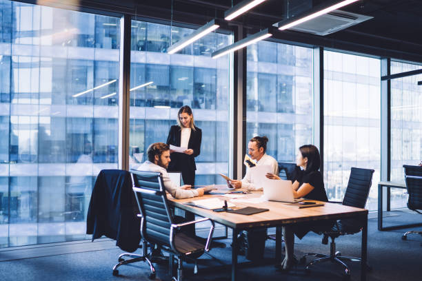 istock Professional financial experts collaborating during brainstorming meeting listening information from clever female director, businesswoman providing information to corporate workers of company 1440061905