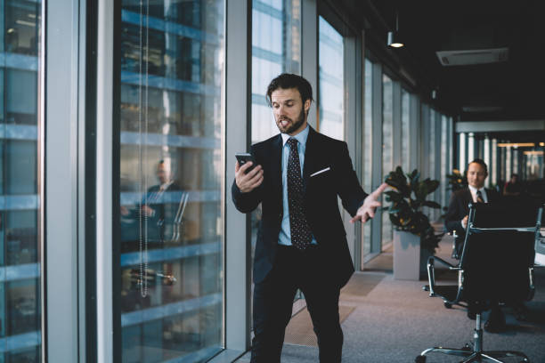 istock Furious male entrepreneur in suit disappointed with bad nes and mails using mobile phone for sending message,expressive caucasian businessman screaming on smartphone having problem with using device 1440062017