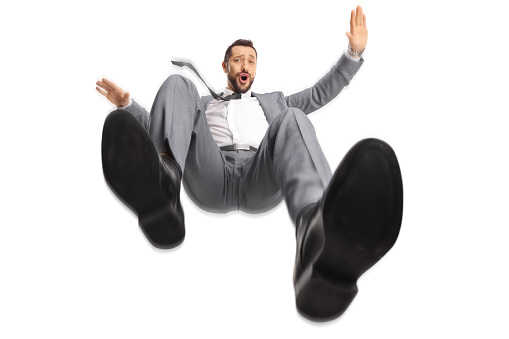 Professional man in a gray suit falling isolated on white background