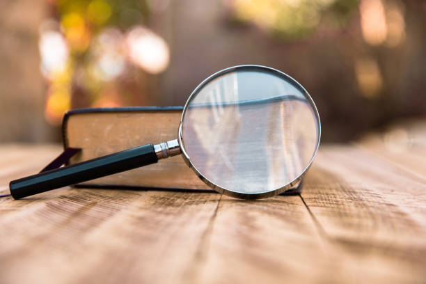 istock Book and magnifier on wooden table 1440065437