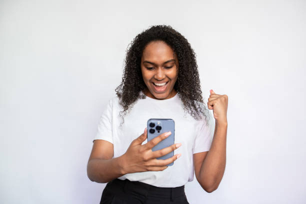 istock Excited young woman reading message and making winning gesture 1440066335