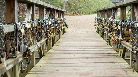 Wedding lock in soft focus as a symbol of love, tenderness, romance, eternity and endless love for lovers. Padlocks are attached to the railings of the bridge. Kuldiga, Latvia.