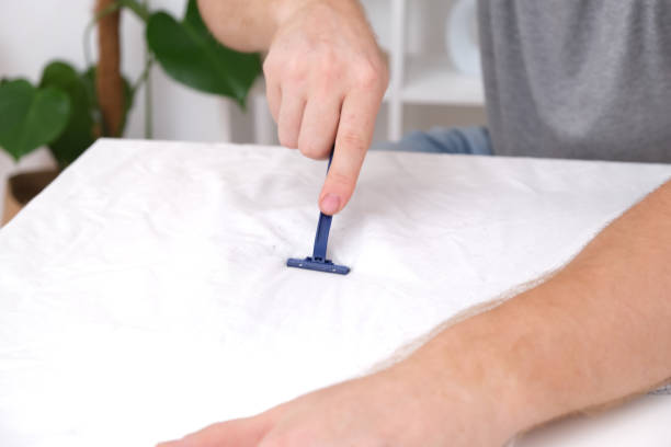 istock A man removes fabric pills using disposable shaving machine. A razor for removing pellets. 1440069141