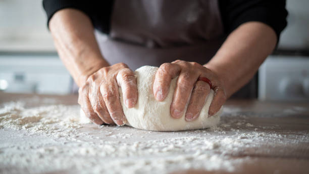 donna anziana in primo piano che fa l'impasto della pizza - impastare foto e immagini stock