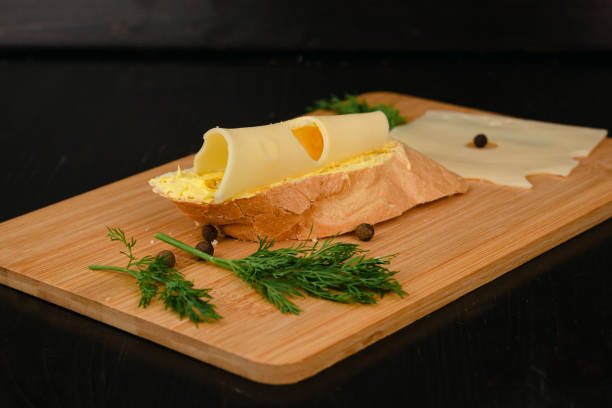 Sandwich with butter and cheese on a wooden board