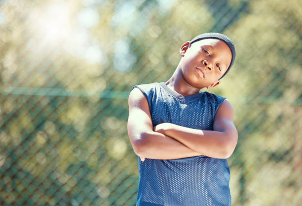 enfant, basket-ball et attitude sérieuse avec un garçon noir debout avec les bras croisés prêt à jouer dehors. enfant fier, confiant et cool avec du butin de rue et prêt à se lever contre l’intimidation - rackets and ball photos et images de collection