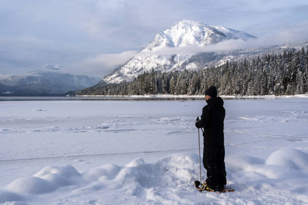 istock Man Looking Across Frozen Lake While Snowshoeing 1440071651