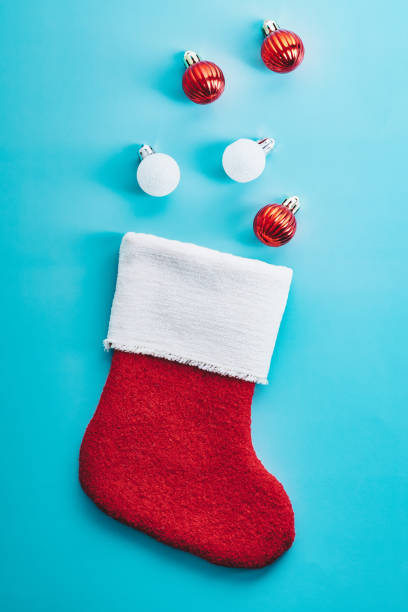 istock Christmas stocking with red and white baubles on blue background 1440072014