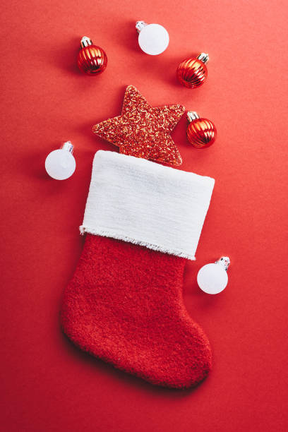 istock Christmas stocking with star and baubles on red background 1440072079