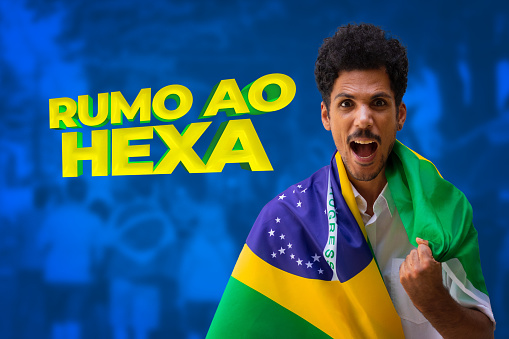 Handsome Black Young Man, Brazilian Player Holding Brazil Flag on Cinematic Background. For social media with copy space.