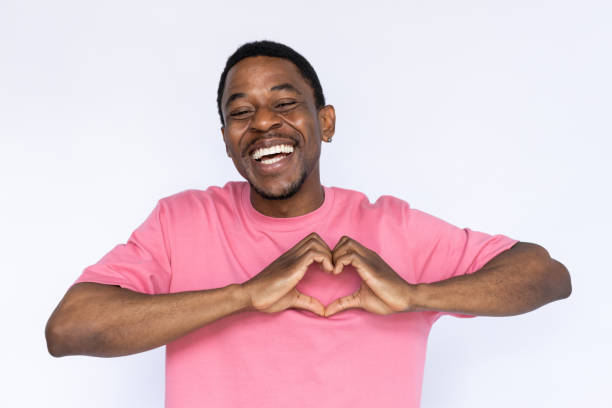 Portrait of excited African American man with heart gesture stock photo