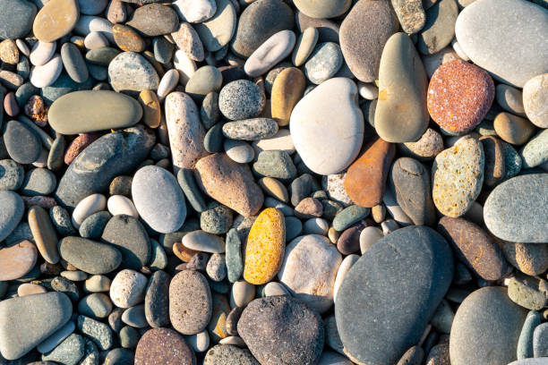 Small, colorful pebbles on the Patagonian beach in Argentina, showcasing natural textures and patterns. Perfect for nature and art projects.