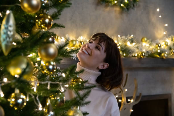 istock Happy woman by Christmas tree 1440077525