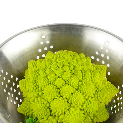 Romanesco broccoli in colander isolated on white background.