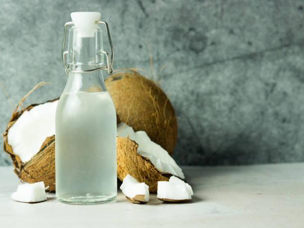 istock fresh refreshing Coconut water in a bottle with an open coconut with white pulp on a concrete background. 1440081358