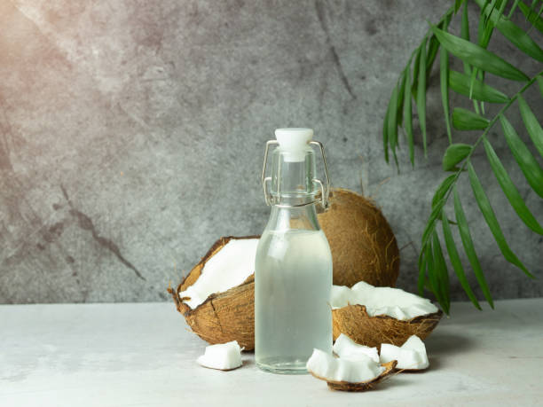 istock fresh refreshing Coconut water in a bottle with an open coconut with white pulp on a concrete background. 1440081359