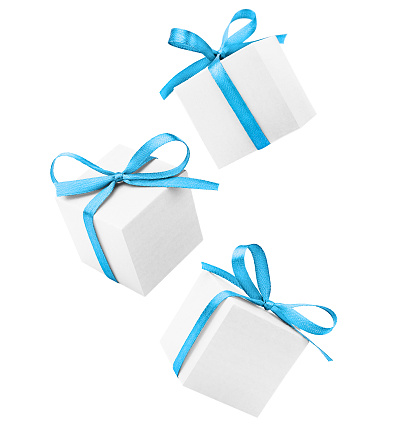 levitation of three white gift boxes with blue bows on a white isolated background