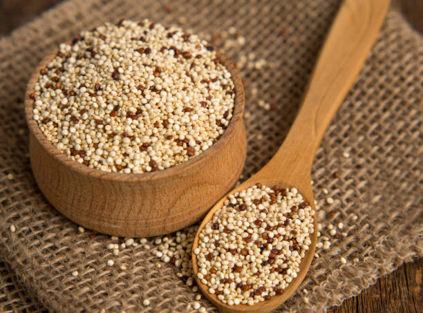 gemischte rohe quinoa in schalen auf holzhintergrund. gesundes und glutenfreies essen. - quinoa stock-fotos und bilder