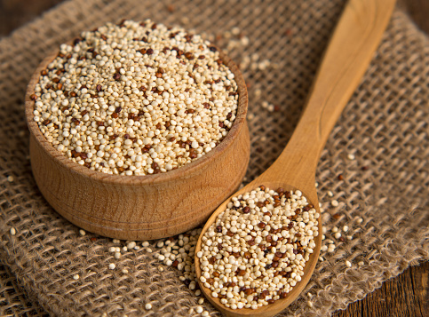 mixed raw quinoa in bowls on a wooden background. Healthy and gluten free food.