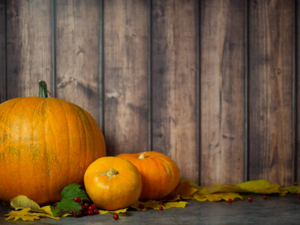 istock autumn halloween pumpkins on wooden background 1440082437