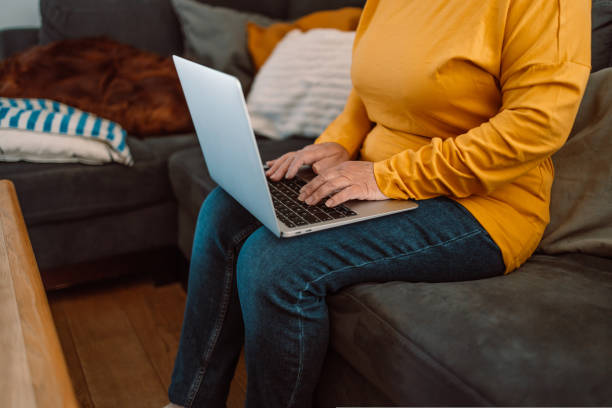 家のインテリアでノートパソコンを使う女性の手。クライアントの電子メールに対するビジネスマンのテキスト応答、webショップサービスを使用してオンラインで購入する顧客。ビジネスと� - connection e mail typing human hand ストックフォトと画像